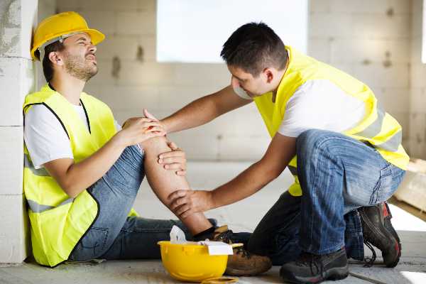 a construction worker attends to his injured co worker